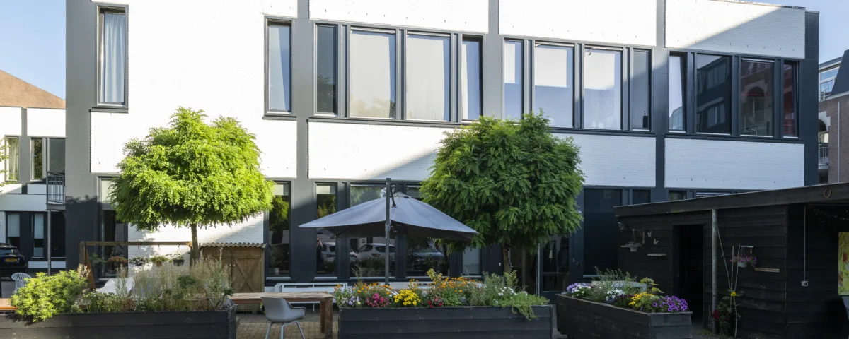 Woonlocatie Haarstraat in Gorinchem met een gezamenlijke binnentuin, bloembakken en zitgelegenheid.