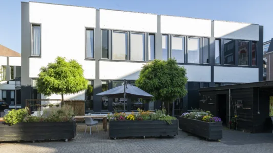 Woonlocatie Haarstraat in Gorinchem met een gezamenlijke binnentuin, bloembakken en zitgelegenheid.