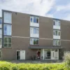 Vooraanzicht van woonlocatie Minnaertweg, een appartementencomplex met meerdere verdiepingen en een centrale entree.