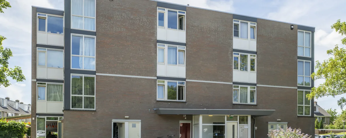 Vooraanzicht van woonlocatie Minnaertweg, een appartementencomplex met meerdere verdiepingen en een centrale entree.