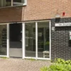 Entree van woongebouw Van Strijsingel met toegangsdeur, brievenbussen en een AED-kast aan de buitenmuur.