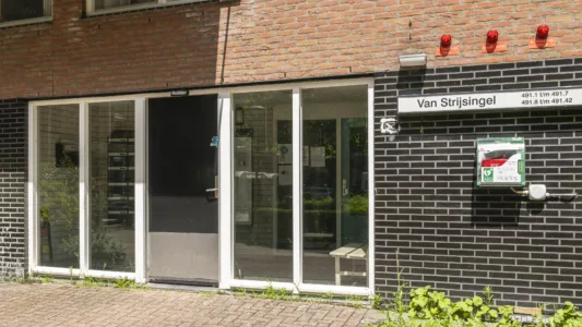 Entree van woongebouw Van Strijsingel met toegangsdeur, brievenbussen en een AED-kast aan de buitenmuur.